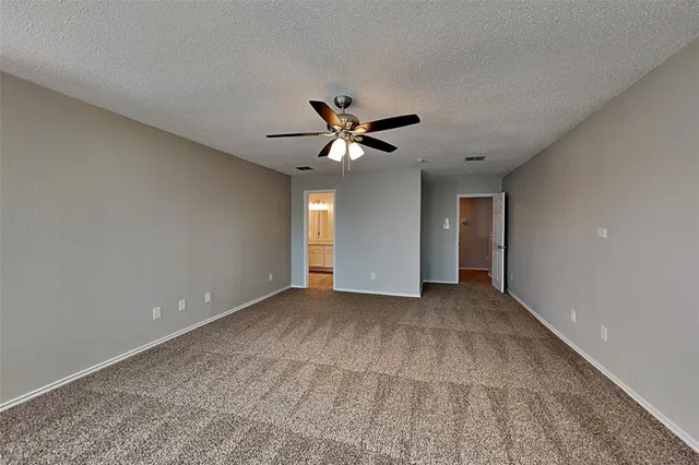 a view of an empty room with a ceiling fan