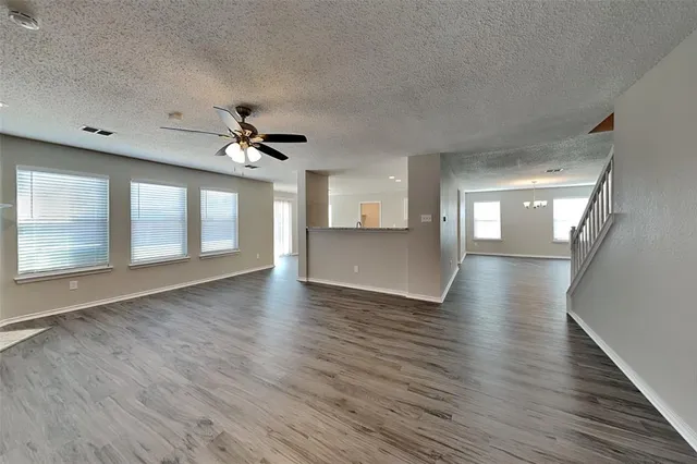 a view of a livingroom with wooden floor and a ceiling fan