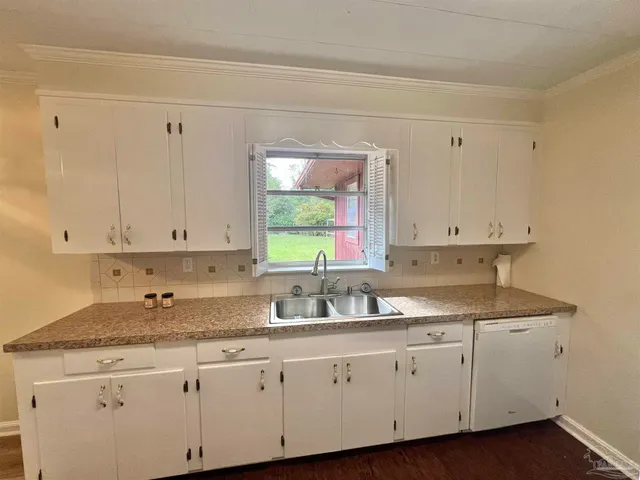 a kitchen with granite countertop white cabinets white appliances and a sink