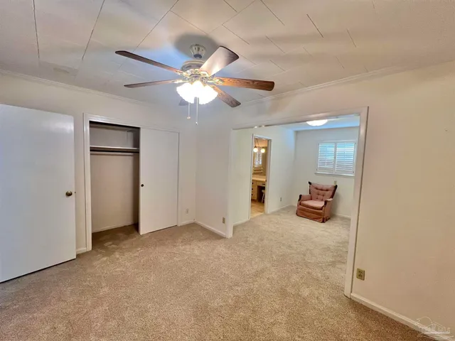an empty room with closet and a chandelier fan