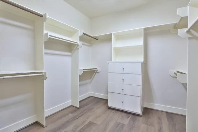 a view of walk in closet with wooden floor