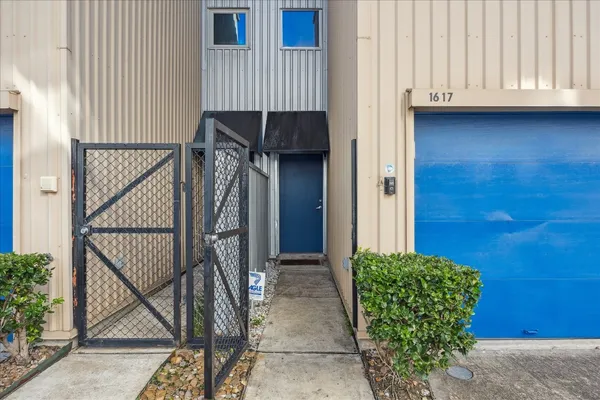 a view of a house with backyard and wooden door