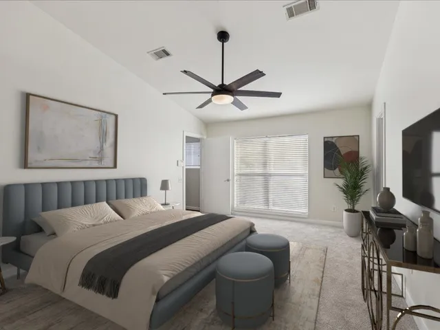 a bedroom with a bed a window and a flat screen tv