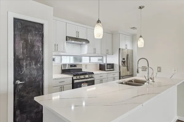 a kitchen with kitchen island a sink stainless steel appliances and cabinets