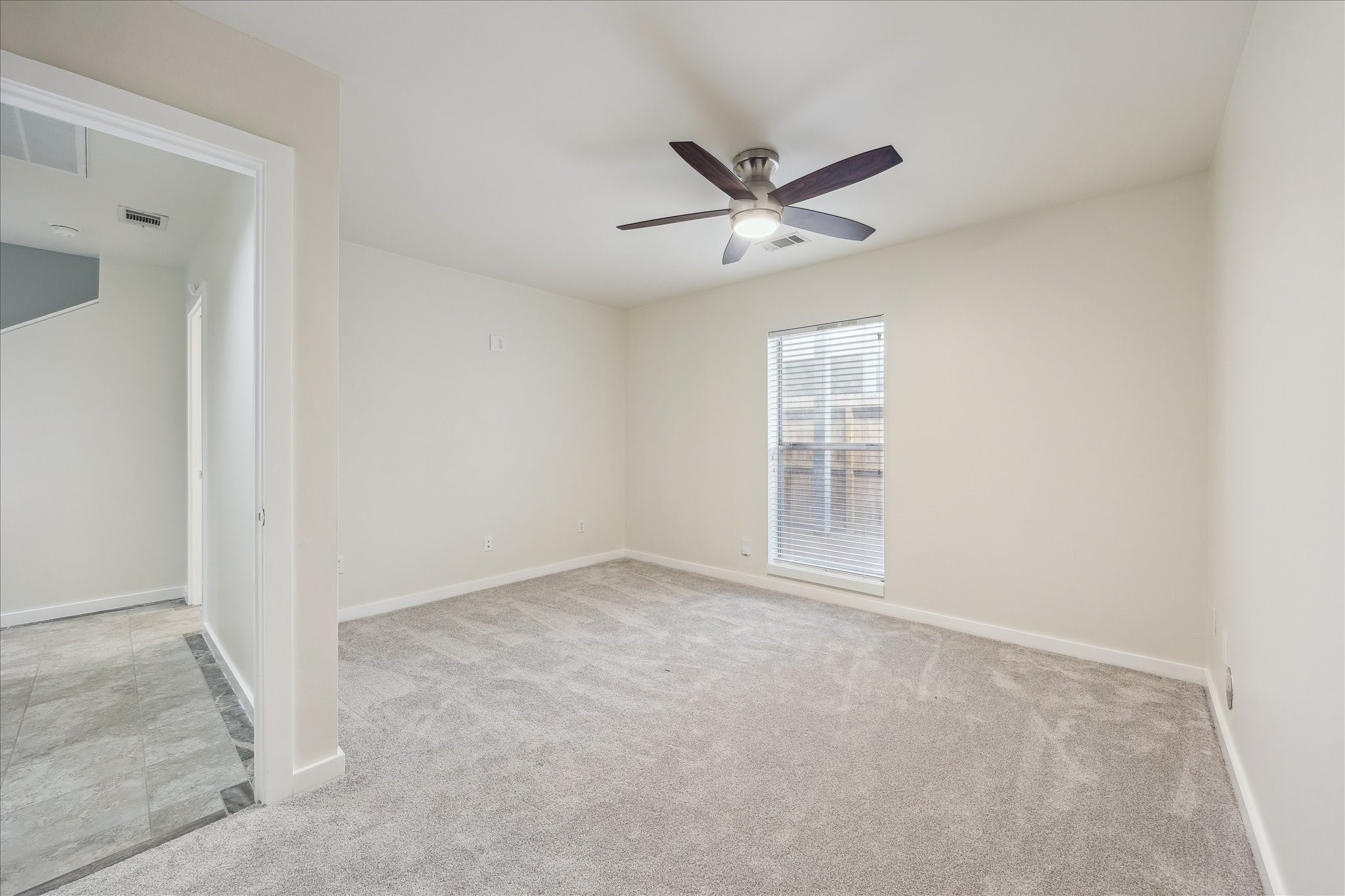 1617 Tuam Street Houston, TX 77004 - Photo 22 of 35 an empty room with a ceiling fan and a window