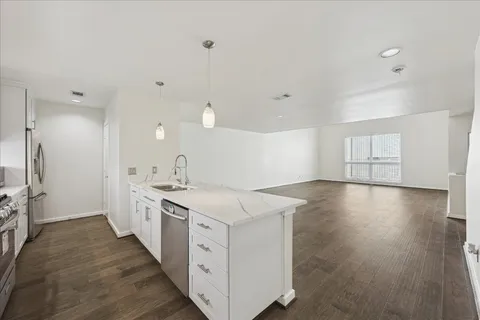 a kitchen with a sink and wooden floor