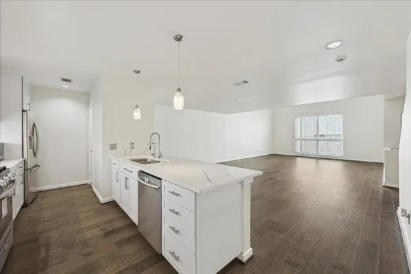 a kitchen with a sink and wooden floor