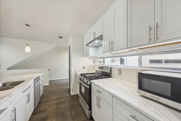 a kitchen with stainless steel appliances granite countertop a stove and a sink