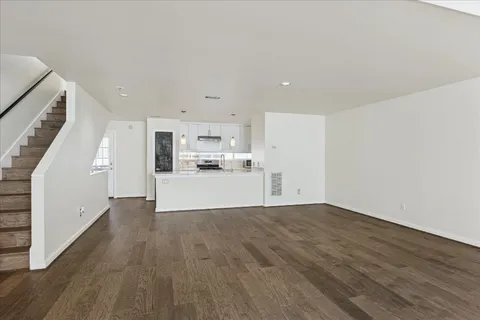 a view of a kitchen with wooden floor and electronic appliances