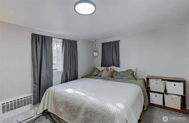 a bedroom with baby bed and a window