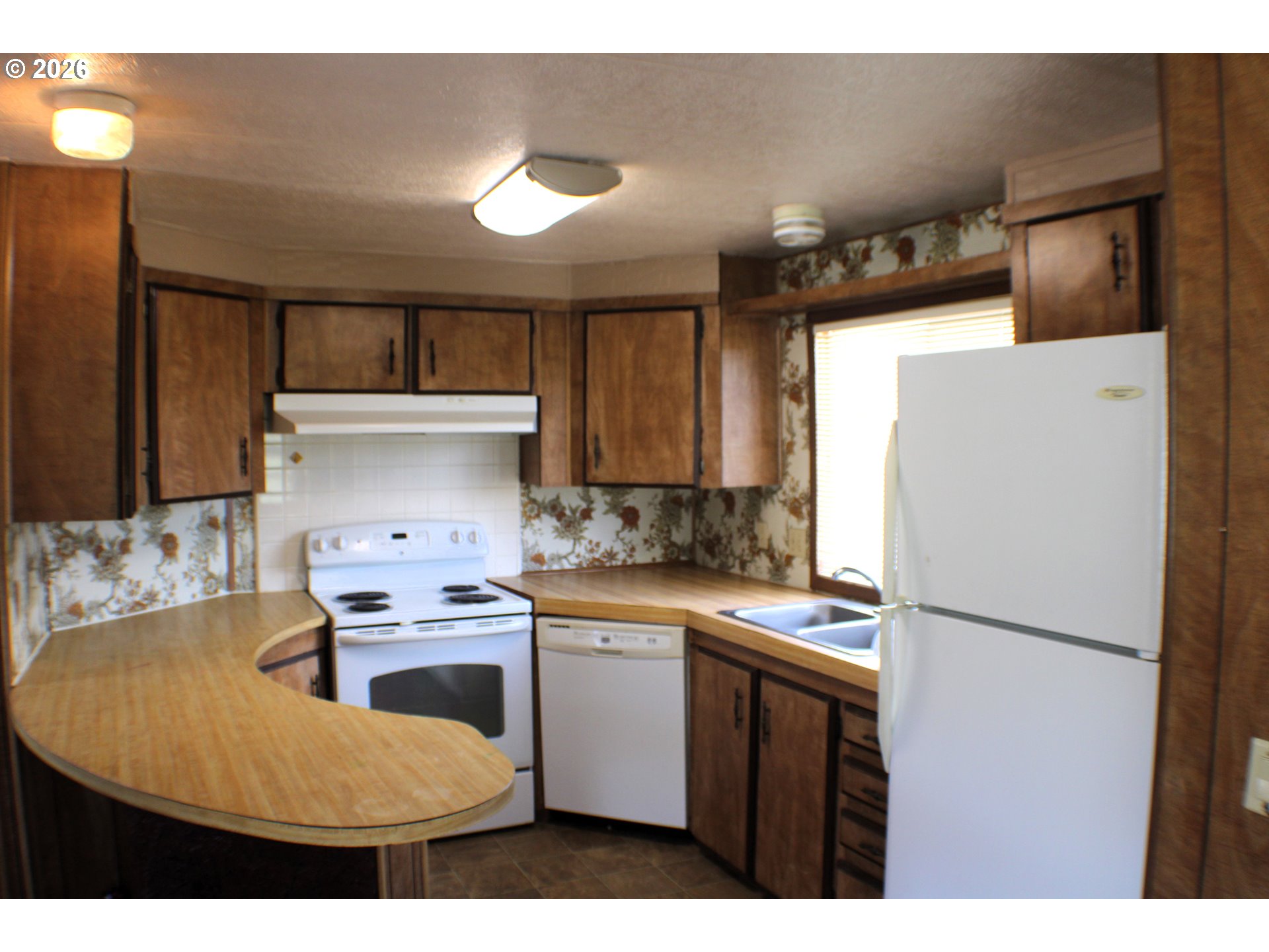 228 Estate Loop Winston, OR 97496 - Photo 11 of 19 a kitchen with kitchen island a stove a refrigerator and a sink