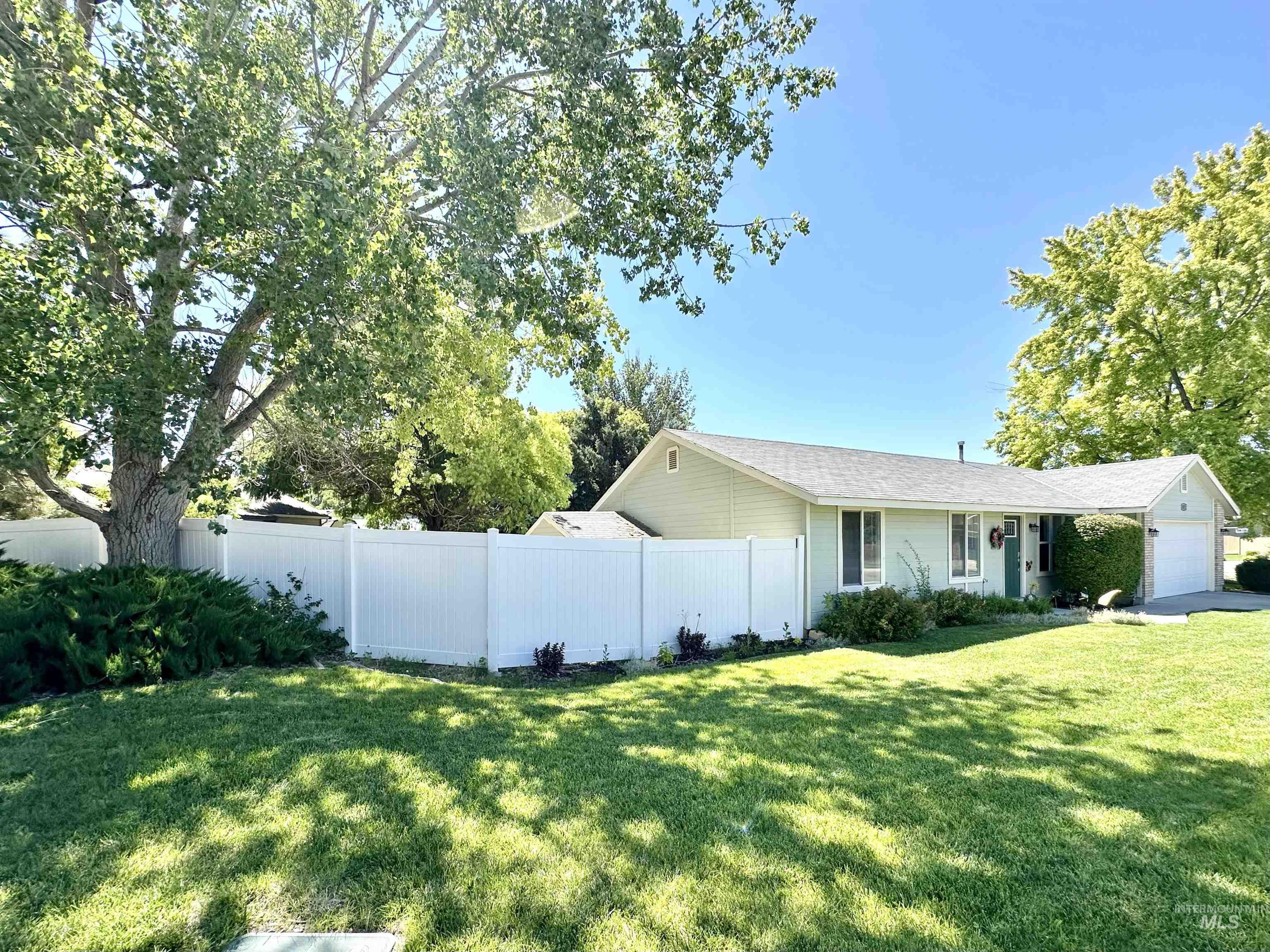 2472 North Maxie Way Meridian, ID 83646 - Photo 3 of 23 Light green siding exterior with white window trim and a white vinyl privacy fence