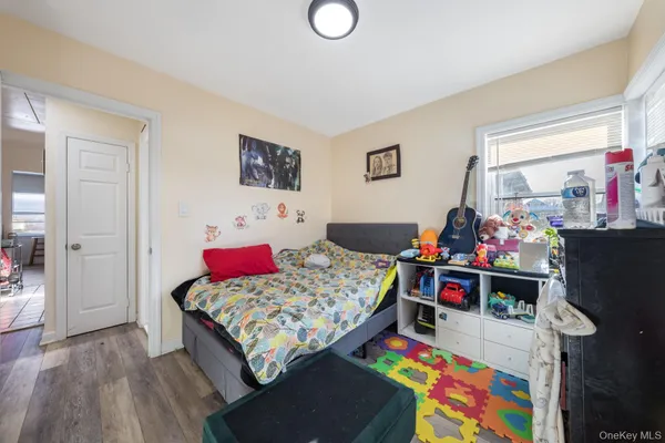 a bedroom with a bed and a wooden floor