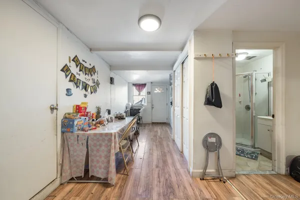 a view of a hallway with wooden floor and a living room