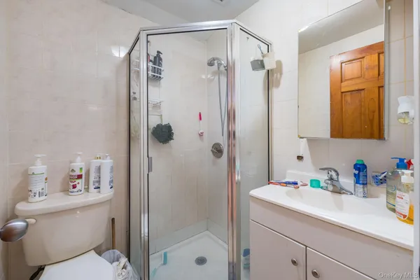 a bathroom with a shower sink vanity mirror and shower