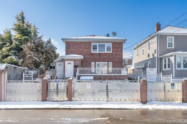 a view of a brick house with many windows next to a road