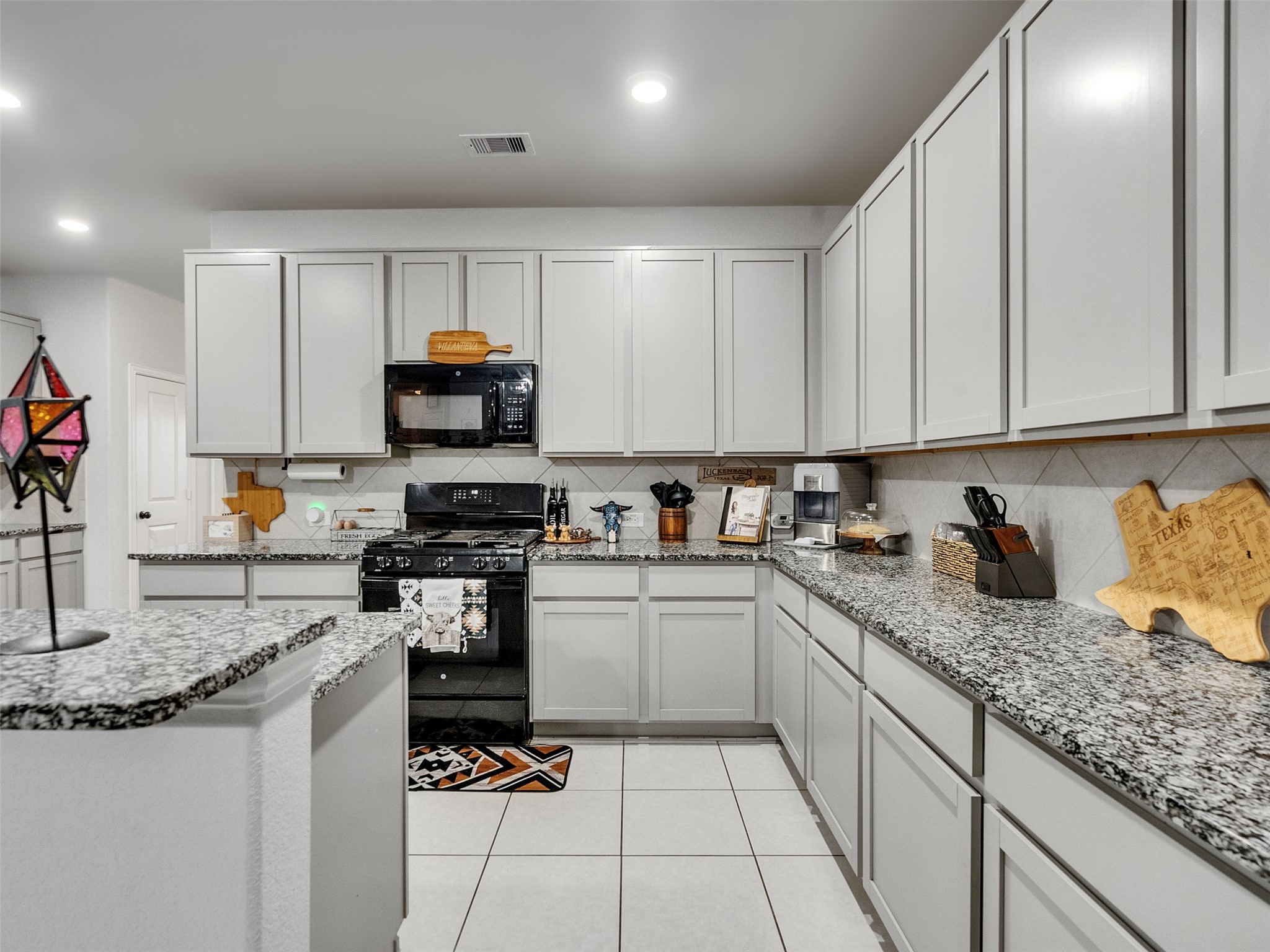 8719 Willet Street Baytown, TX 77521 - Photo 27 of 42 a kitchen with granite countertop a sink stainless steel appliances and white cabinets
