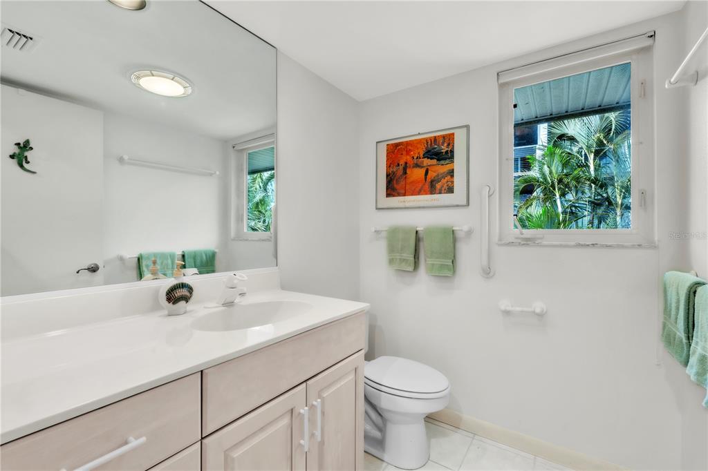 103 Sunset Lane Anna Maria, FL 34217 - Photo 14 of 53 a bathroom with a sink a mirror and a toilet