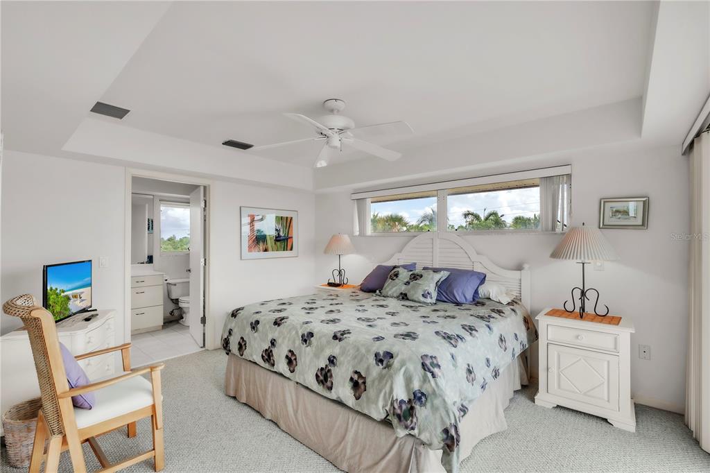 103 Sunset Lane Anna Maria, FL 34217 - Photo 43 of 54 a bedroom with a large bed and a chandelier