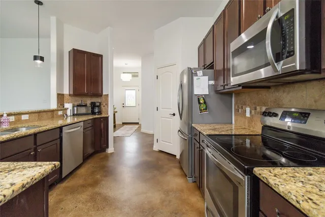 a bathroom with a granite countertop toilet sink and mirror