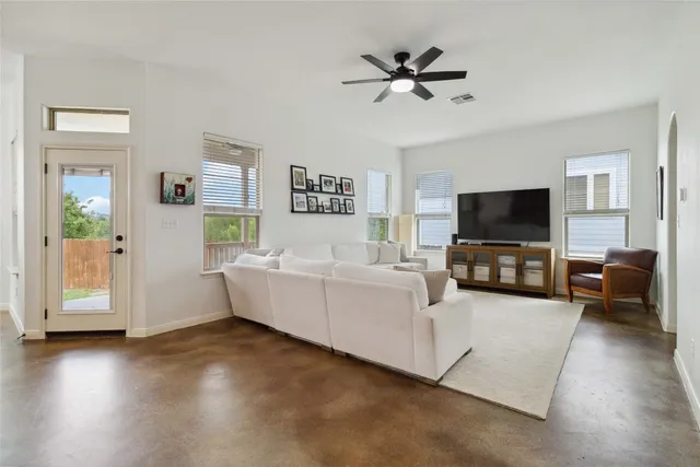 a living room with furniture and a view of kitchen