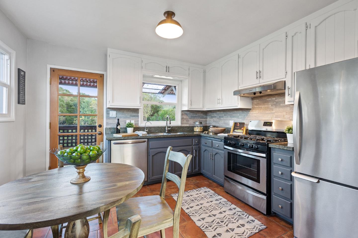 3946 La Colina Road El Sobrante, CA 94803 - Photo 11 of 49 a kitchen with stainless steel appliances granite countertop a stove a refrigerator a sink a dining table and chairs with wooden floor