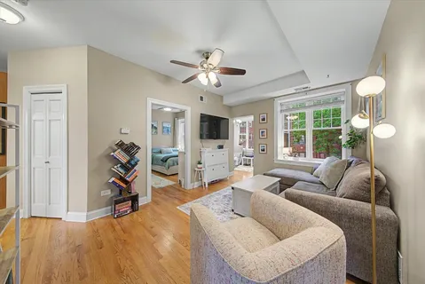 a living room with furniture a flat screen tv and a large window