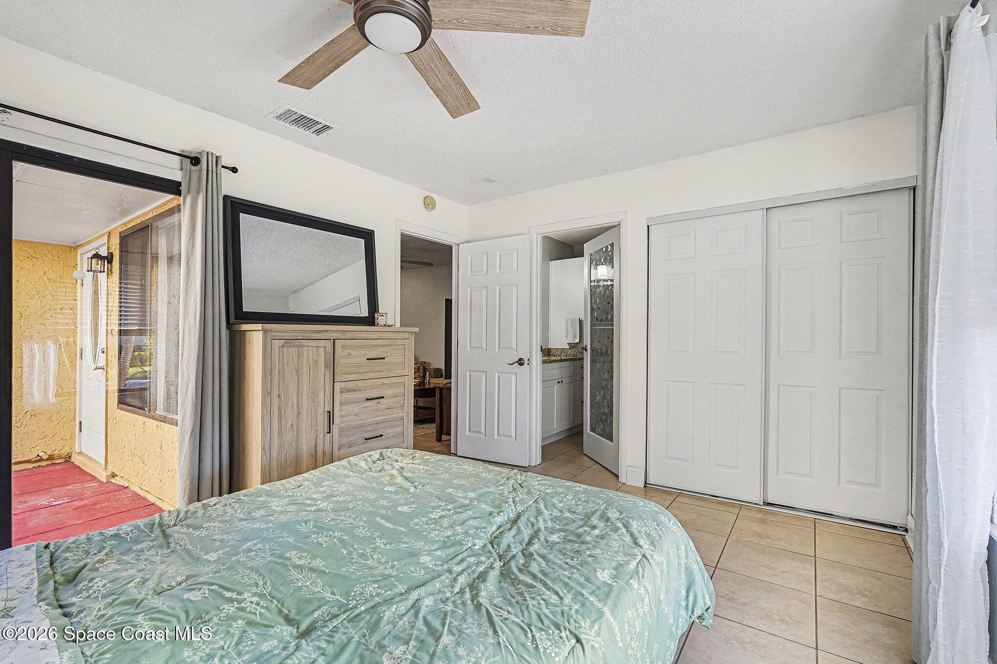 1491 Sheafe Avenue Northeast, Unit 104 Palm Bay, FL 32905 - Photo 10 of 19 a bedroom with a bed and a flat screen tv
