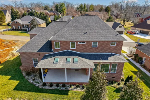 an aerial view of a house with swimming pool and large trees
