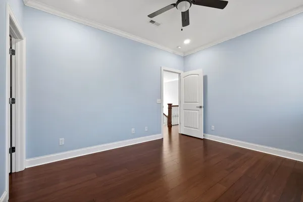 a view of an empty room with wooden floor and a cabinet