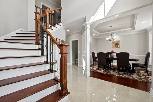 a kitchen with stainless steel appliances granite countertop a refrigerator a sink a stove a dining table and chairs