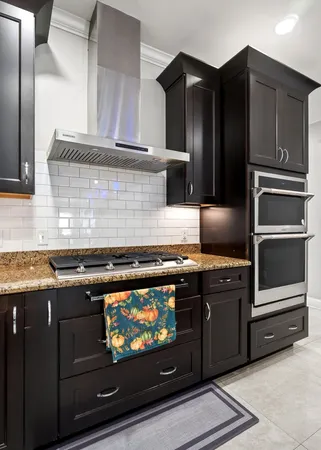 a kitchen with stainless steel appliances granite countertop a table chairs sink refrigerator and cabinets