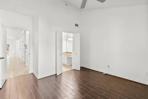 a view of a room with wooden floor and a bathroom