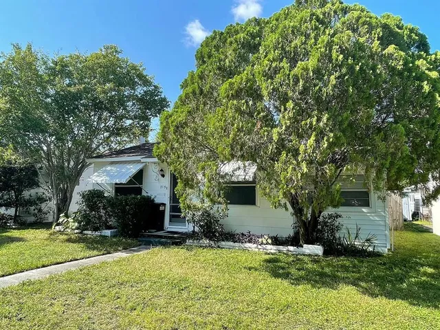 a front view of a house with a yard garage and trees