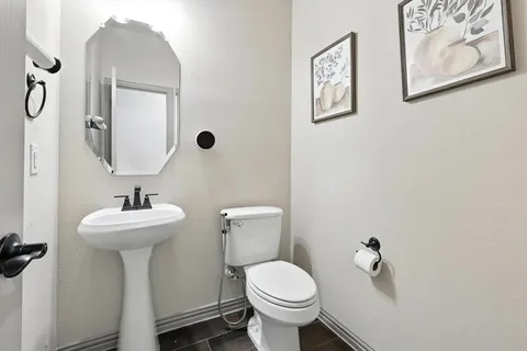 a bathroom with a toilet sink and mirror