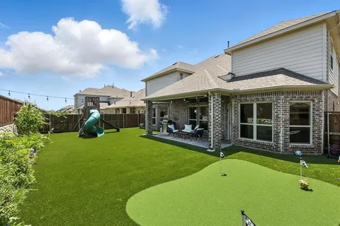 a view of a house with a backyard and porch
