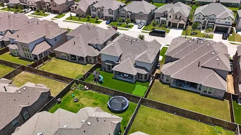 an aerial view of a house with a swimming pool and outdoor seating