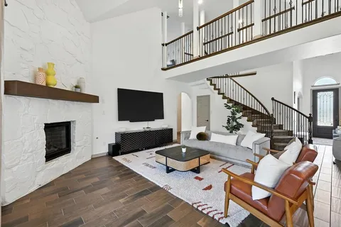 a living room with furniture a flat screen tv and a fireplace