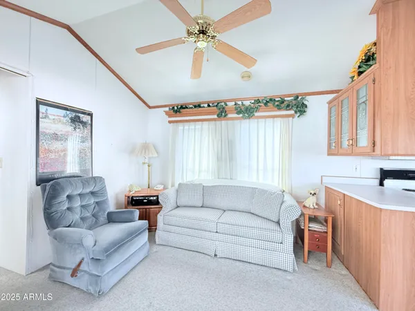 a living room with furniture a ceiling fan and a window