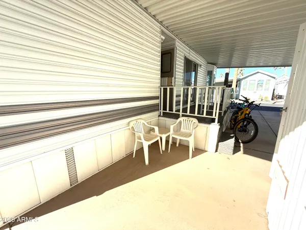 a view of a patio with a table and chairs and a barbeque