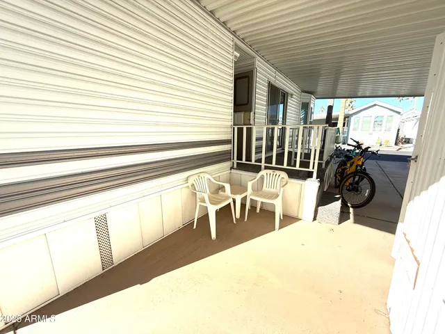 a view of a patio with a table and chairs and a barbeque