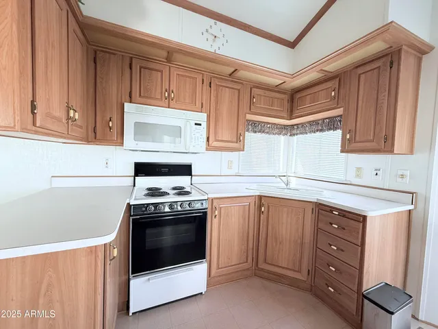 a kitchen with sink a stove and cabinets