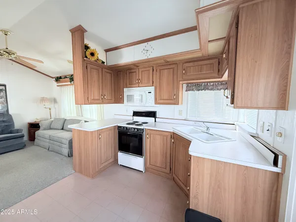 a kitchen with granite countertop a sink stove and cabinets
