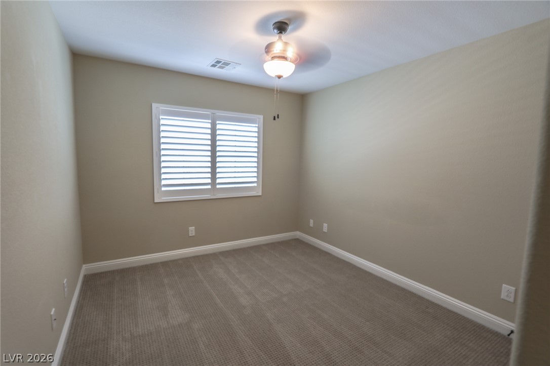 1509 Destiny Ridge Court Henderson, NV 89074 - Photo 19 of 29 Patterned carpeting and neat window shutters define this comfortable bedroom space.
