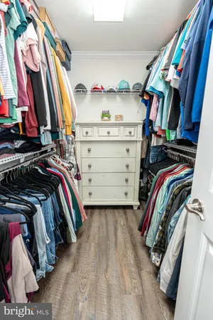 a view of walk in closet with clothes and shoes