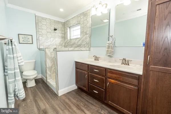 a bath room with a sink a toilet and a mirror