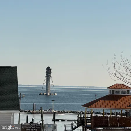 a view of a lake with a table and chairs under an umbrella
