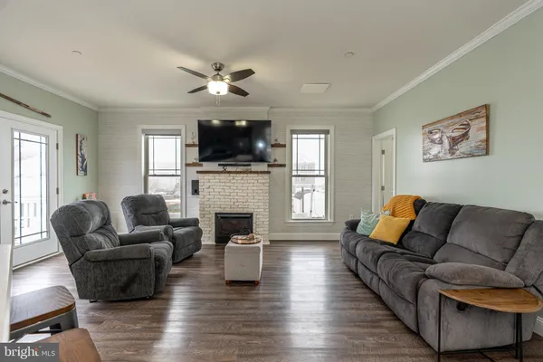 a living room with furniture a fireplace a flat screen tv and a window