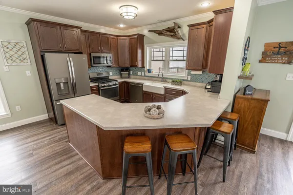 a kitchen with stainless steel appliances a table chairs refrigerator and microwave