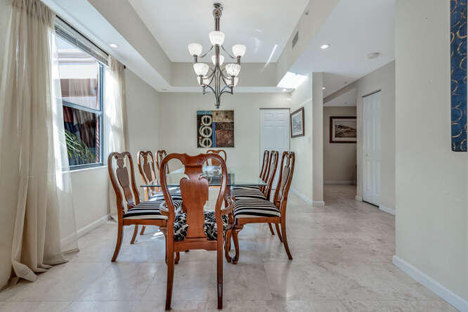 1640 Presidential Way, Unit 501 West Palm Beach, FL 33401 - Photo 17 of 36 a view of a dining room with furniture and a chandelier
